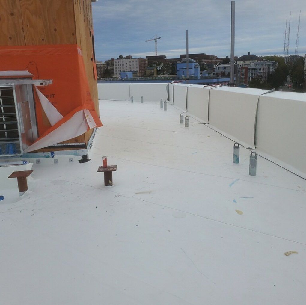 A white roof is being installed on a building