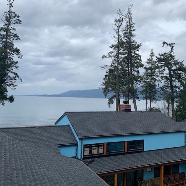 A blue house with a view of the water in the background