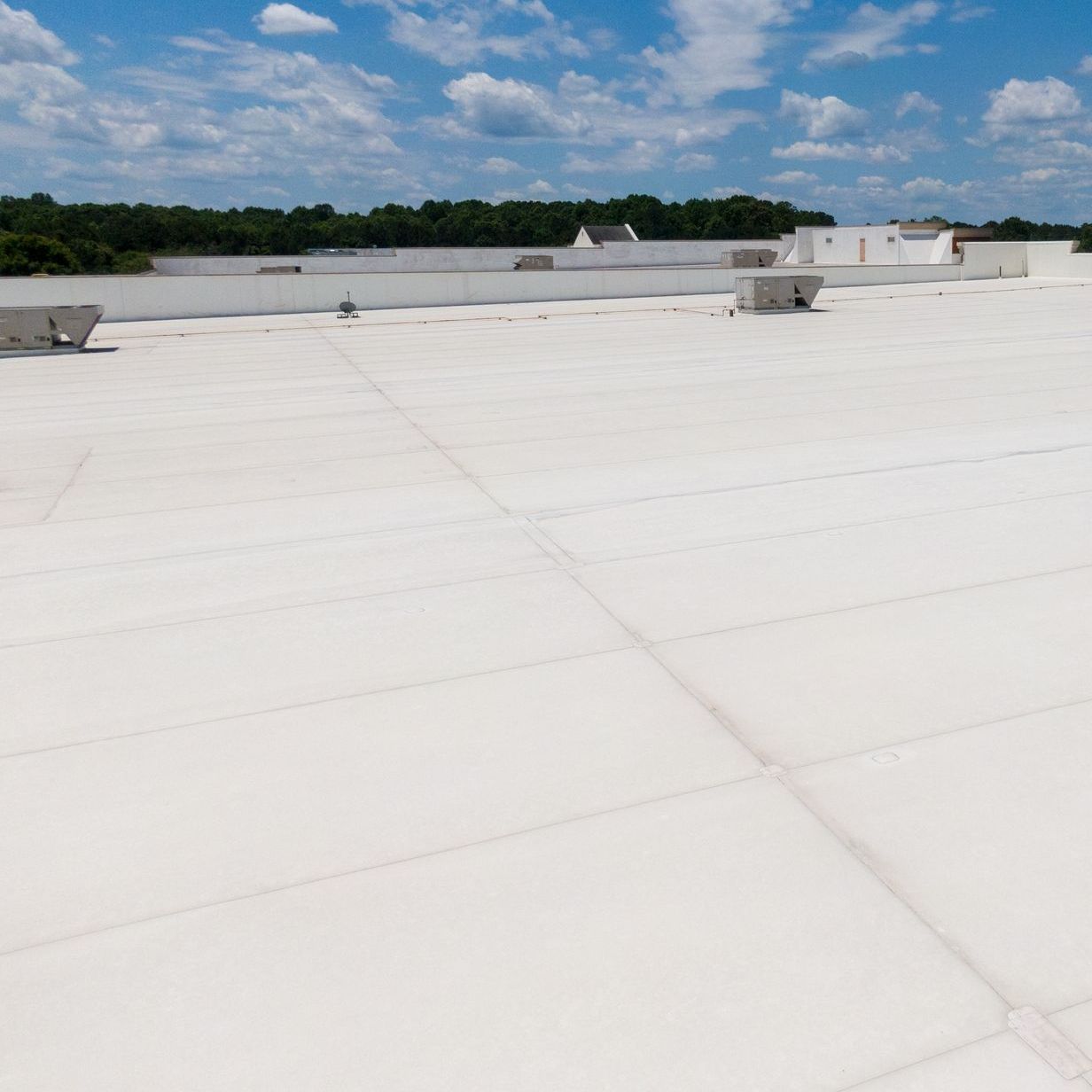 A large commercial flat roof with a blue sky in the background.