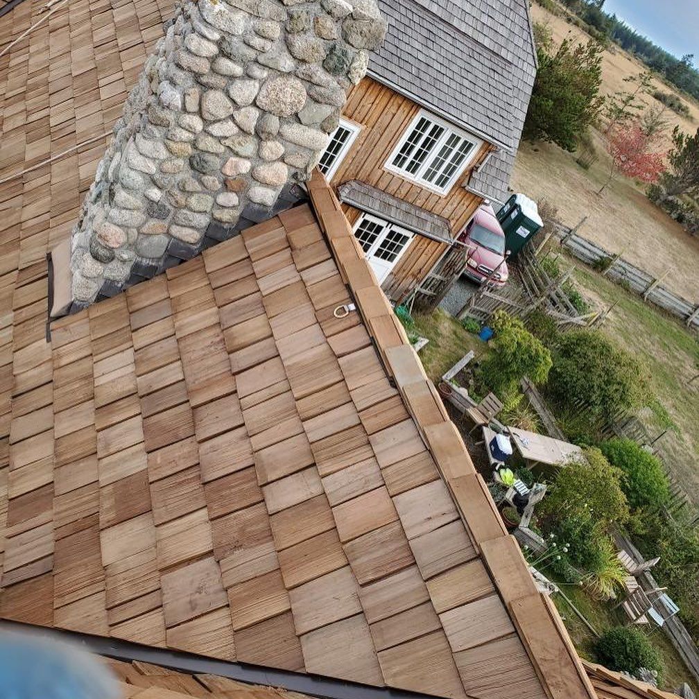 An aerial view of a house with a wooden roof and a stone chimney.